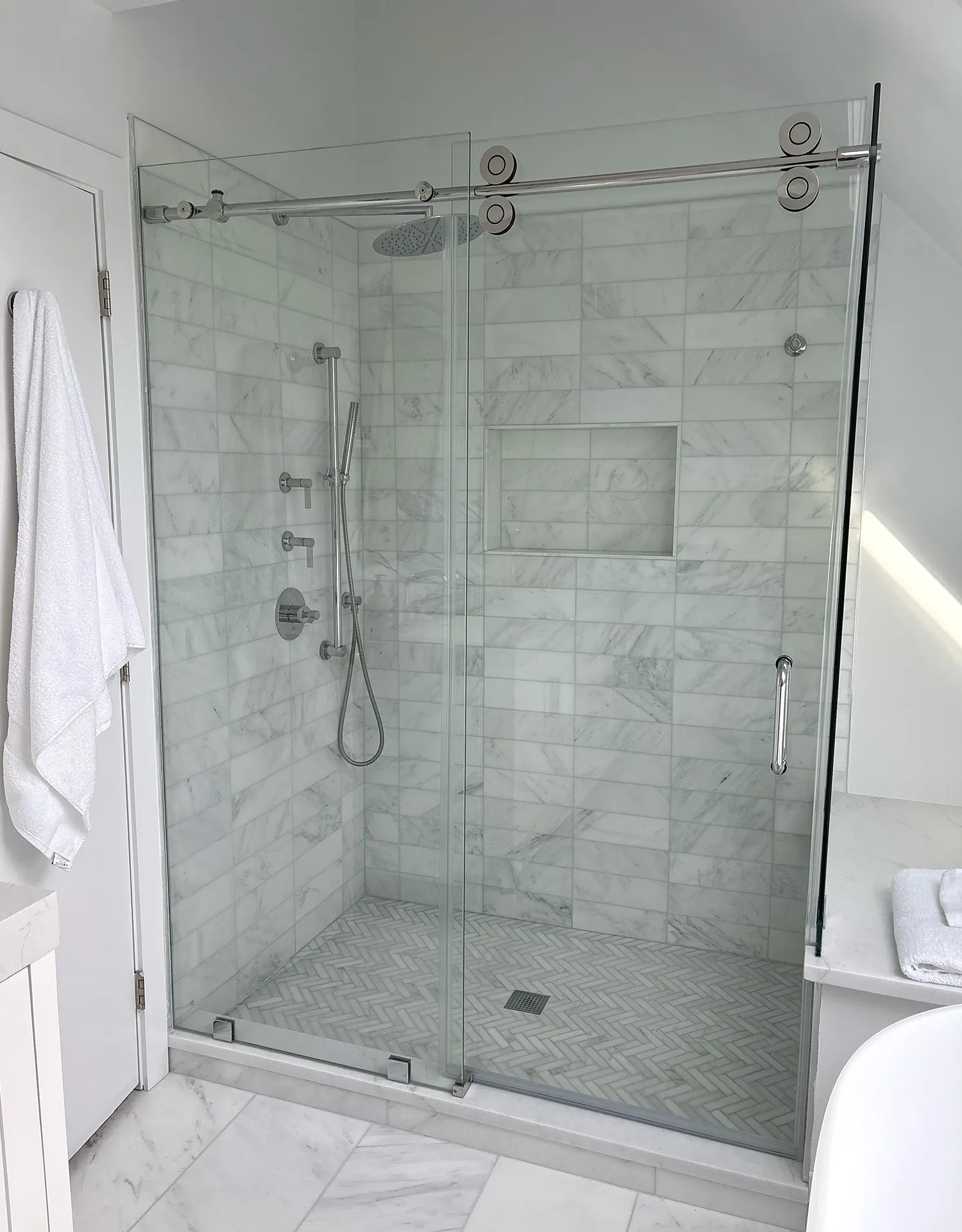 Frameless glass walk-in shower with marble tile