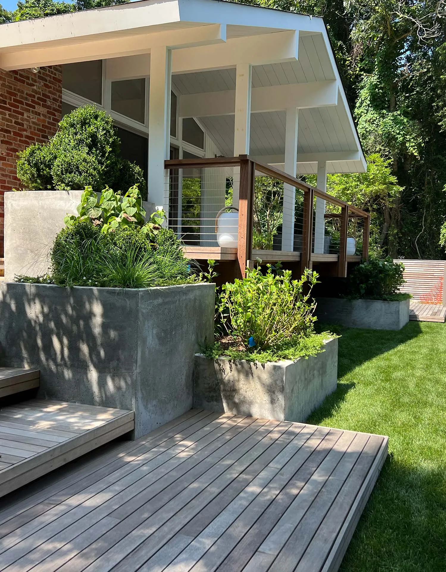 Hamptons home terrace with concrete planters and a wood deck